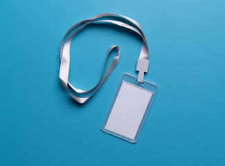 Mockup of a blank white ID card with a white lanyard on orange background