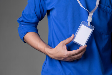man holding id tag on brown background