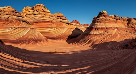 Naklejka premium Marvel at the flowing lines and vibrant colors of the sandstone at The Wave, a natural wonder under a clear blue sky.