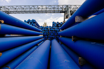 Stack of cast iron pipes in loading area waiting for transportation