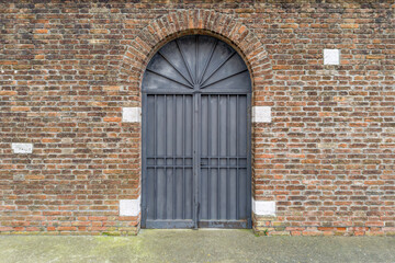 Arched Iron Gate in Brick Wall Facade