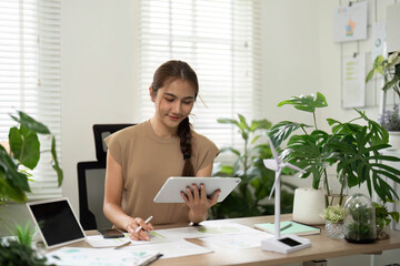 ESG sustainability initiatives with woman using tablet in green office