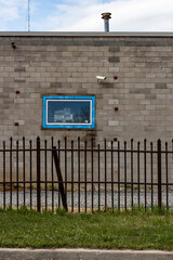 Industrial Building with Security Camera and Metal Fence