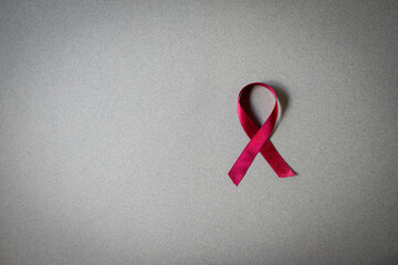 Red ribbon on grey background with copy space