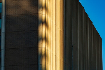 Modern Building Facade with Sunlit Textures and Architectural Details