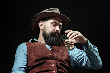 Cognac glass held by bearded man. Guy drinking cognac alone at bar. Whiskey cognac in classic vintage glass. Cognac tasting with retro style. Expensive whisky. Drink whisky concept. Alcoholic beverage