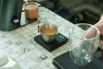 Freshly brewed espresso resting on digital scale in cafe, precise measurement reflecting barista craftsmanship, warm inviting ambiance expressing love and care of small family business,