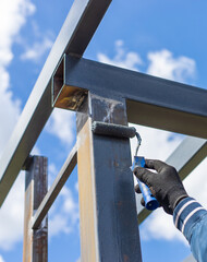 Man painting metal poles. Selective focus.