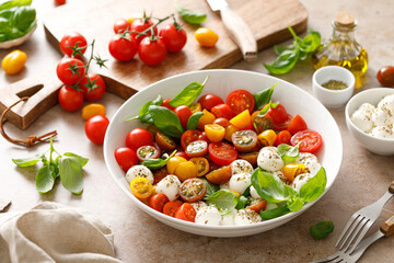 Salad with fresh cherry tomatoes, mozzarella and basil leaves