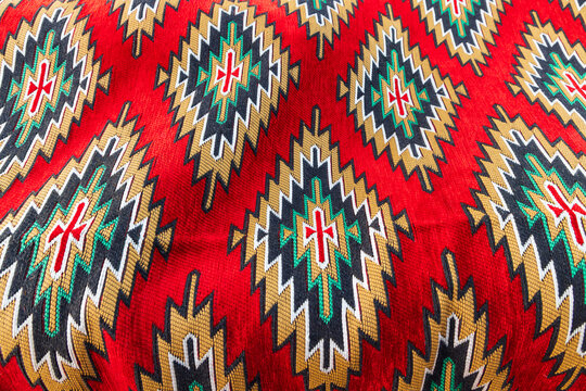 Geometric pattern in a brightly colored woven rug.