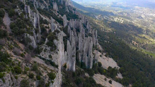 Aerial view of Els Frares. The topography, with its rock formations, casts a striking silhouette. Its striking structures resemble monks turned to stone, in Alicante, Spain.