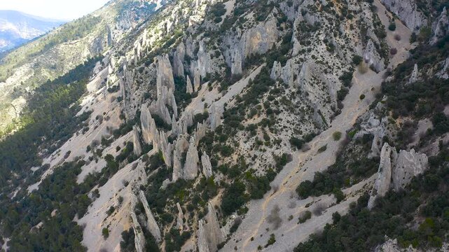 Aerial view of Els Frares. The topography, with its rock formations, casts a striking silhouette. Its striking structures resemble monks turned to stone, in Alicante, Spain.