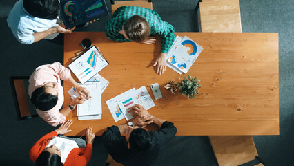 Top view of business man using tablet display increasing graph while diverse marketing people...