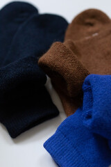 Close-up texture socks three pairs of warm socks on white background blue brown black