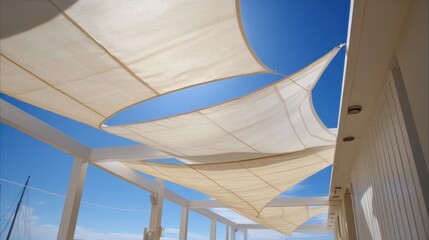 Fototapeta premium Chic Terrace in Summer Featuring Stylish Shade Sails Against a Blue Sky