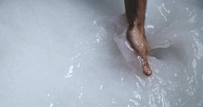 Super Slow Motion of Hand Stirring White Paper Pulp in Vat During Traditional Papermaking Process - Close-Up of Artisan Mixing Slurry for Sheet Formation in Handmade Paper Craft Workshop at 1000 fps.