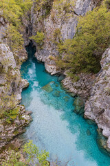 Clear aque blue water of the Valbonas River in a rocky canyon.