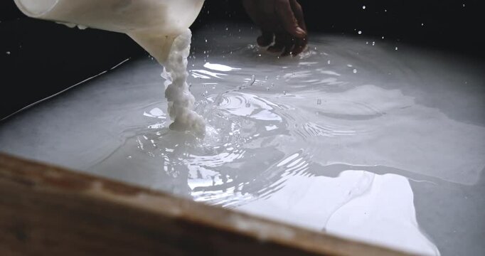 Super Slow Motion of Pouring White Pulp into Water Basin During Traditional Handmade Paper Making Process - Close-up of Fiber Suspension Mixing in Preparation for Sheet Formation at 1000 fps.
