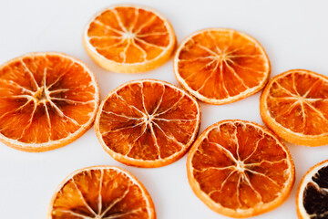 Dried orange slices arranged on a white surface for decoration and culinary use