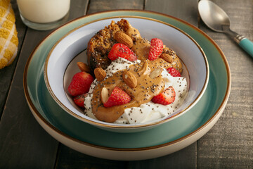Healthy bowl of fruit cake with yogurt,peanut butter,strawberries and chia seeds.