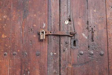 Padlock on an old wooden door.