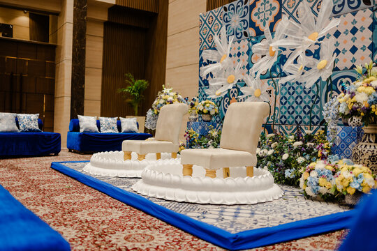 Ceremonial seating arrangement with decorative backdrop, vibrant colors, and plush seating for a special event or celebration.
