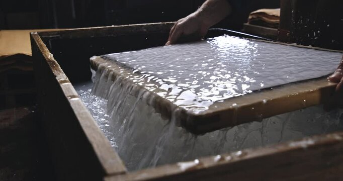 Super Slow Motion of Removing Sheets of Handmade Paper from Water Vat During Traditional Papermaking Process in Artisan Workshop with Natural Fibers and Wooden Tools at 1000 fps.