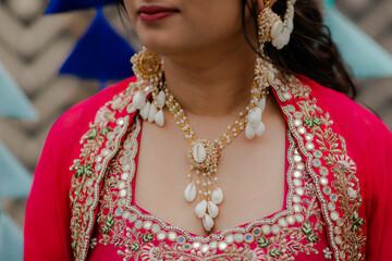 Woman adorned in exquisite pearl and shell jewelry, complementing her vibrant attire, creating a...