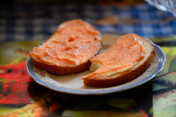 Close-up of two slices of white bread generously topped with delicious red caviar spread, served on a decorative plate. Simple yet appetizing snack or breakfast, ready to eat.
