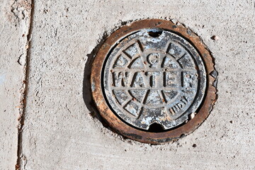 Water access manhole in sidewalk.