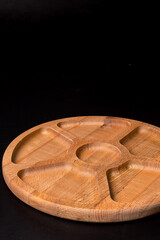 Empty round minazhnitsa made of wood on a black background