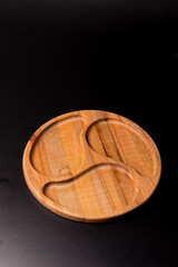 Empty round minazhnitsa made of wood on a black background