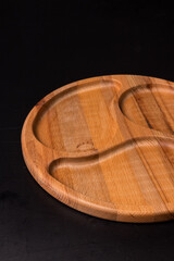 Empty round minazhnitsa made of wood on a black background