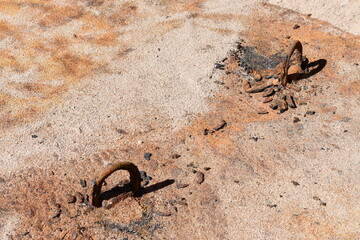 Iron loops sticking out of dirt.