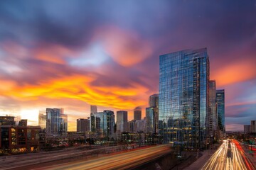 Fototapeta premium Modern city skyline with a dynamic colorful sunset casting vivid hues across sleek skyscrapers and reflecting off glass facades Generative AI