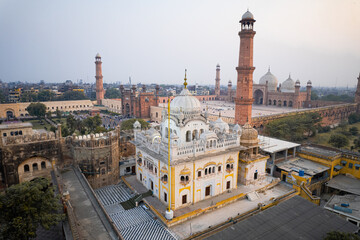 Obraz premium Aerial view of Lahore featuring Gurdwara Dera Sahib, Samadhi of Ranjit Singh, and Badshahi Mosque.