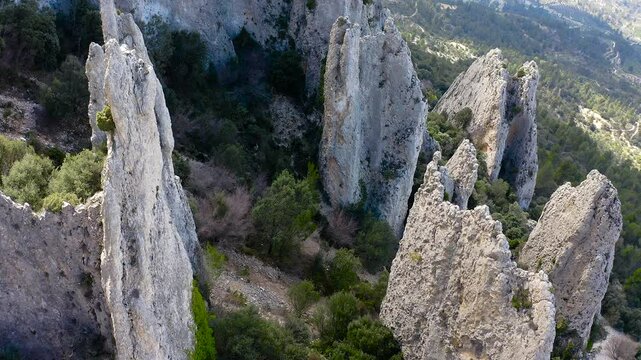 Aerial view of Els Frares. The topography, with its rock formations, casts a striking silhouette. Its striking structures resemble monks turned to stone, in Alicante, Spain.
