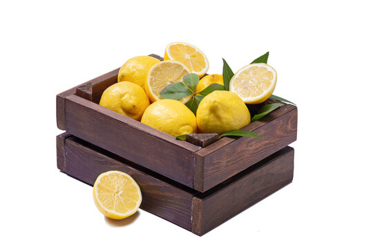 Fresh and ripe lemons on wooden box isolated on white