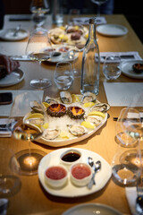 Champagne tasting, Wine glasses are on the table, stylish table setting, sparkling wine bubbles, oysters and sea urchins, special sauce