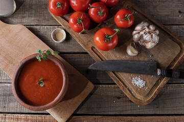 Top view of tomatoes and garlic for sauce preparation in a rustic setting.