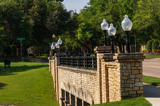 Classic Stone Bridge with Globe Lamp Posts in a Green Suburban Park in Plano Texas