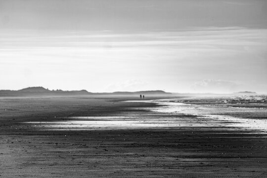 Holkam beach with two people walking awy