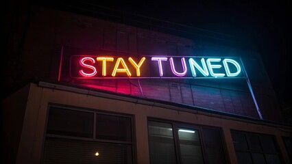 Neon sign displaying the words "stay tuned" in bright colors against a dark background