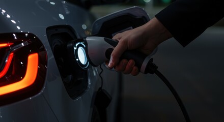 Focus on hand inserting EV plug into car socket. Symbol of clean energy adoption and environmental consciousness. High detail close-up.