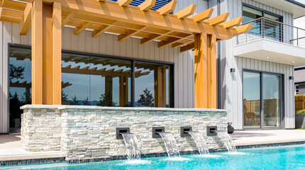 three cascading water features in a modern home's backyard pool
