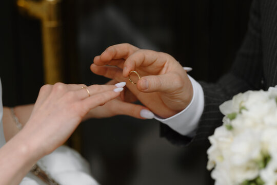 Bride and groom exchanging wedding rings during ceremony, symbolizing love, commitment, and unity together.