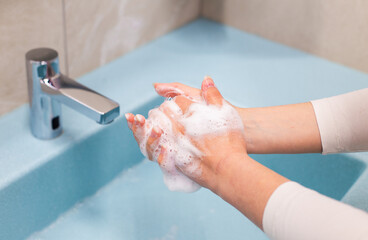 Hand washing with soap and water at sink