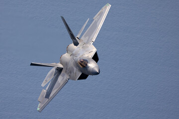 Close view of a a F-22 Raptor  in a turn, flying over the Pacific ocean