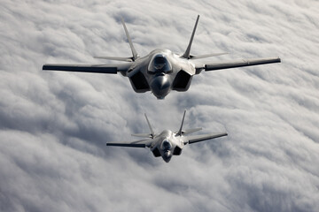 Very  close top view of a pair of F-35C Lightning II   over clouds in beautiful light