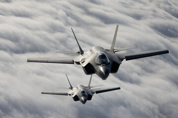 Very  close top view of a pair of F-35C Lightning II   over clouds in beautiful light